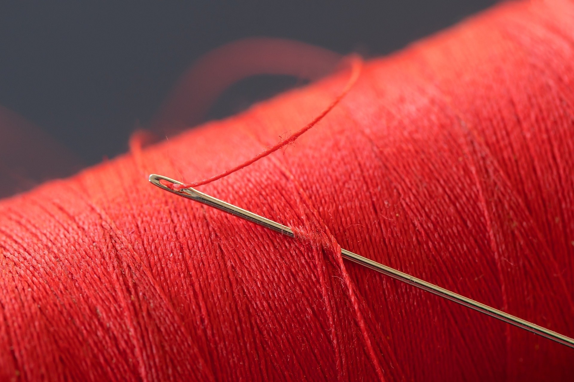 Needle with red thread on a spool