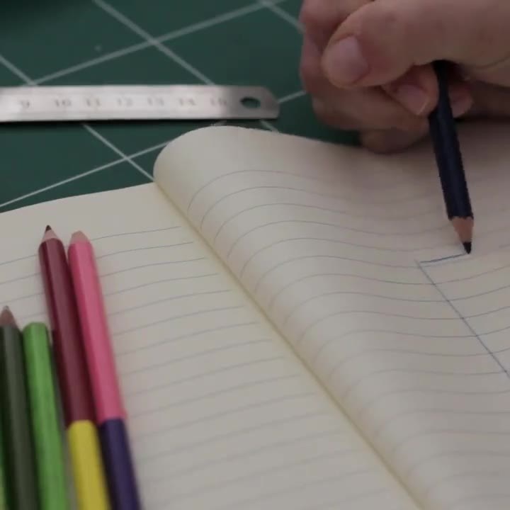 Eine Hand skizziert mit Bleistift in einem Notizbuch